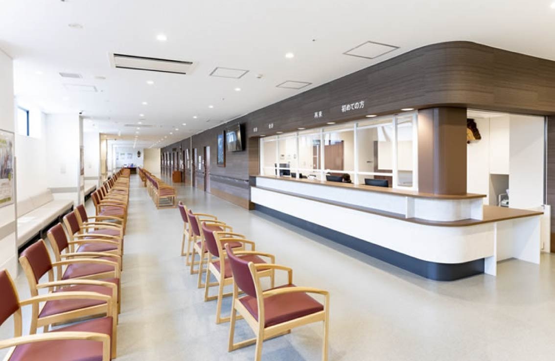 受付カウンターと患者様用の椅子が並んでいる様子。清潔感があり、落ち着いた雰囲気の院内です。